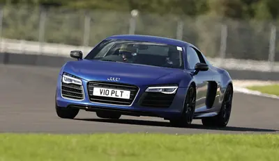 Blue Audi R8 in the pit lane at Donington Park, driver in helmet nearby