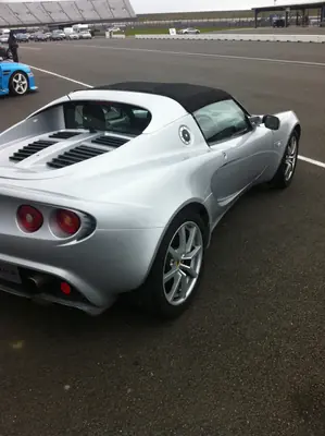 Silver Lotus Elise parked trackside, rear three-quarter view