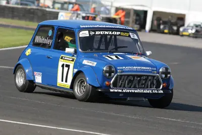 Classic racing Mini cornering hard on circuit during a competitive race