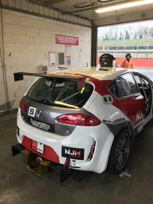 White and red SEAT touring race car in the pit garage