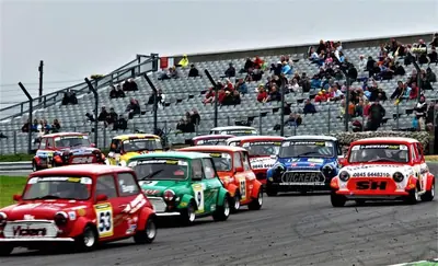 Grid of classic racing Minis lined up at the start of a Mini Miglia Challenge race